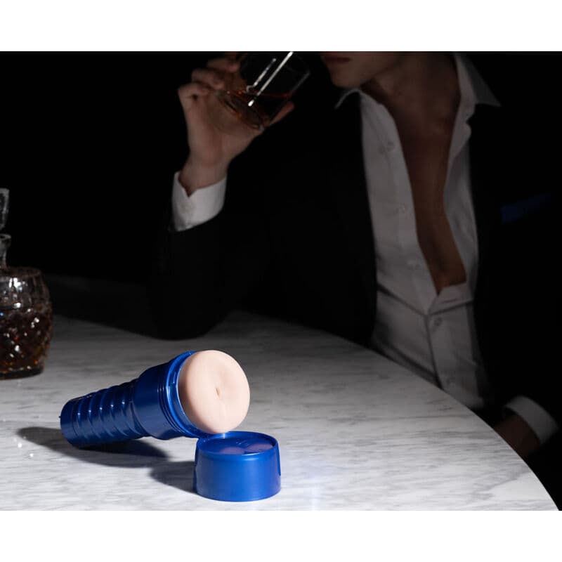 Masturbateur BLAST LM CHAIR RP - BOOST - FLESHLIGHT mannequin homme qui bois un verre avec le produit à son côté posé sur une table